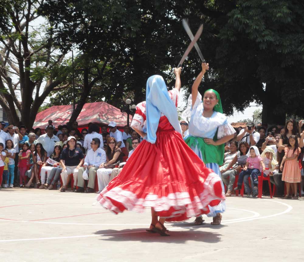 Mujeres vestidas con trajes típicos colombianos realizando una danza tradicional.