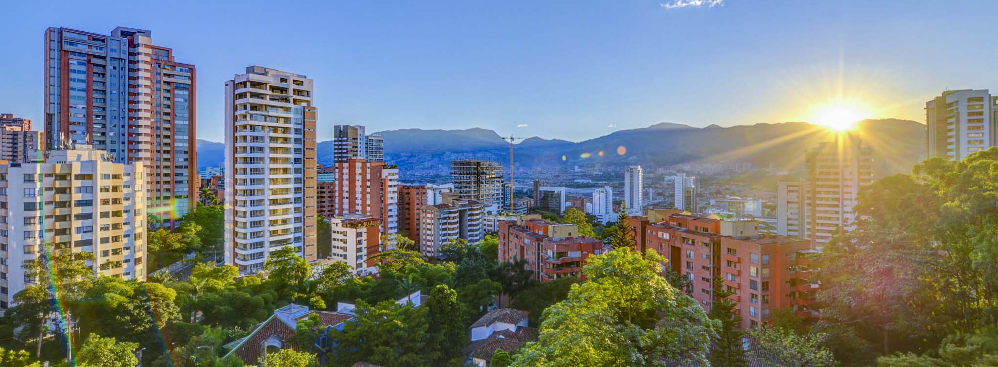 Vista panorámica de Medellín al atardecer, mostrando edificios residenciales.