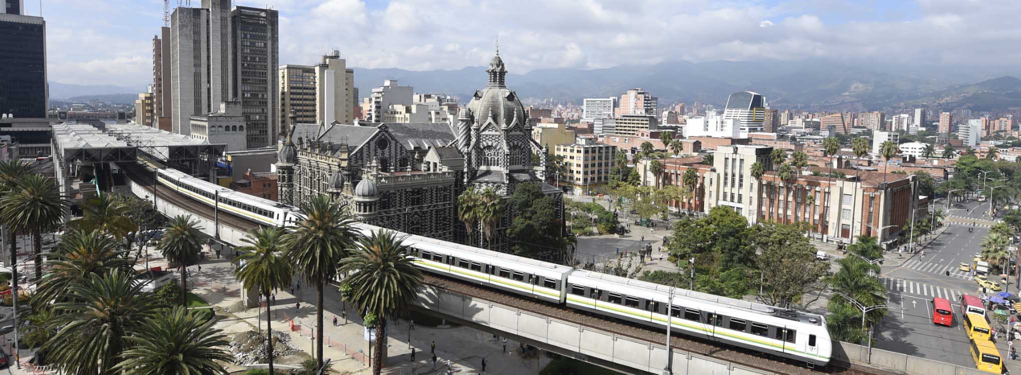 Vista panorámica de Medellín mostrando el sistema de metro elevado, el edificio histórico del Museo de Antioquia.