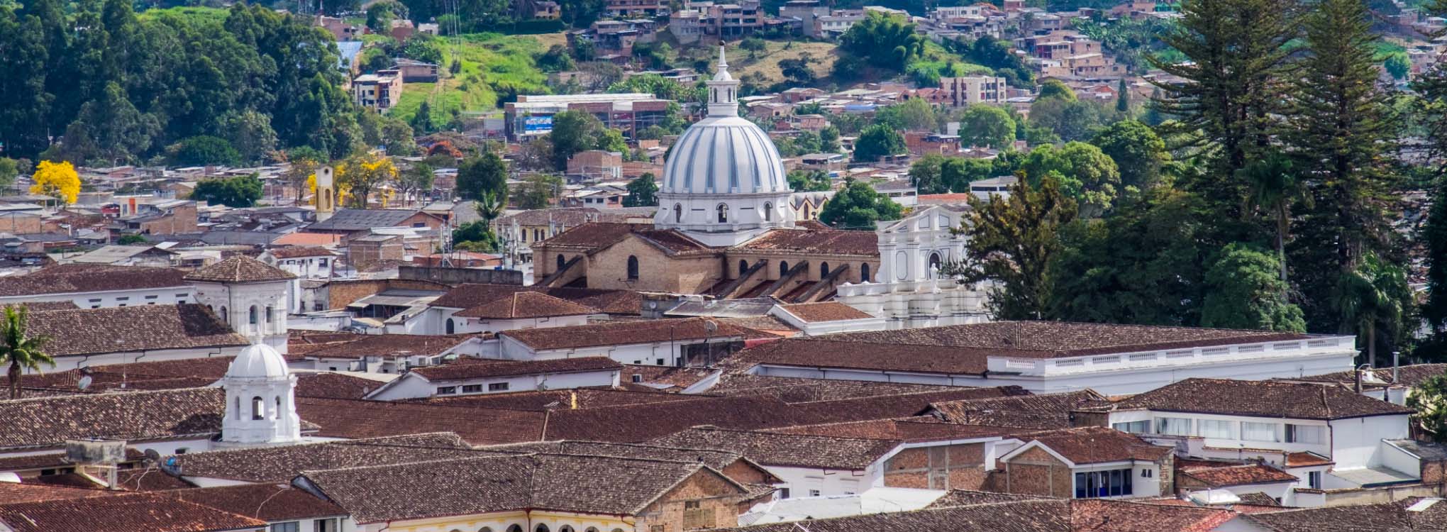 Vista panorámica de Popayán, Cauca, mostrando techos tradicionales de tejas rojas y la icónica cúpula de una iglesia.