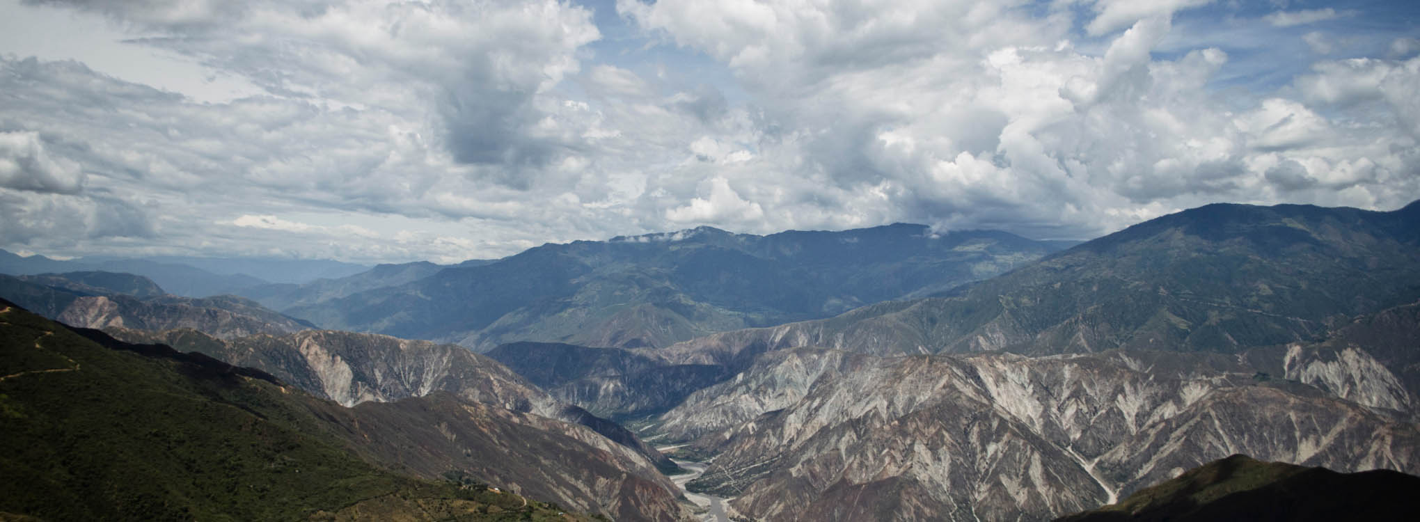 Panorámica del majestuoso Cañón del Chicamocha en Santander, rodeado de montañas y cielos despejados.