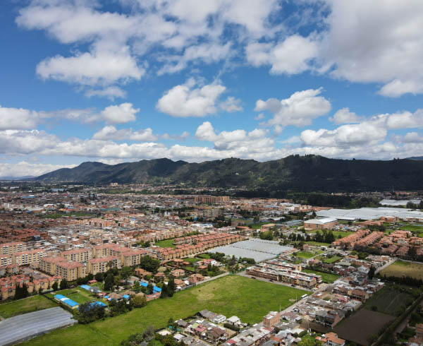 ista aérea de una ciudad en Cundinamarca, rodeada de montañas y cielos despejados.