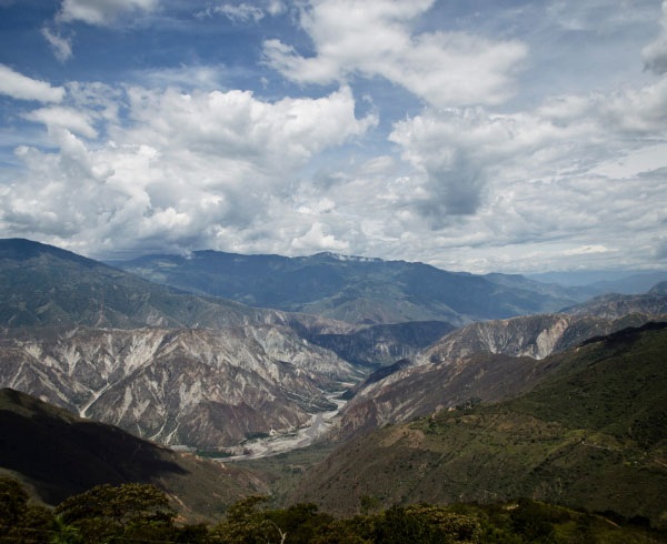 Panorámica del majestuoso Cañón del Chicamocha en Santander, rodeado de montañas y cielos despejados.