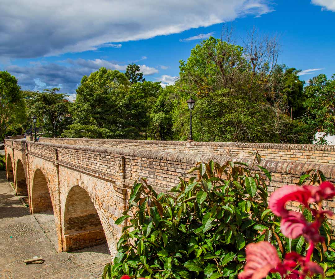 Puente de ladrillo histórico con arcos múltiples que cruza un río.