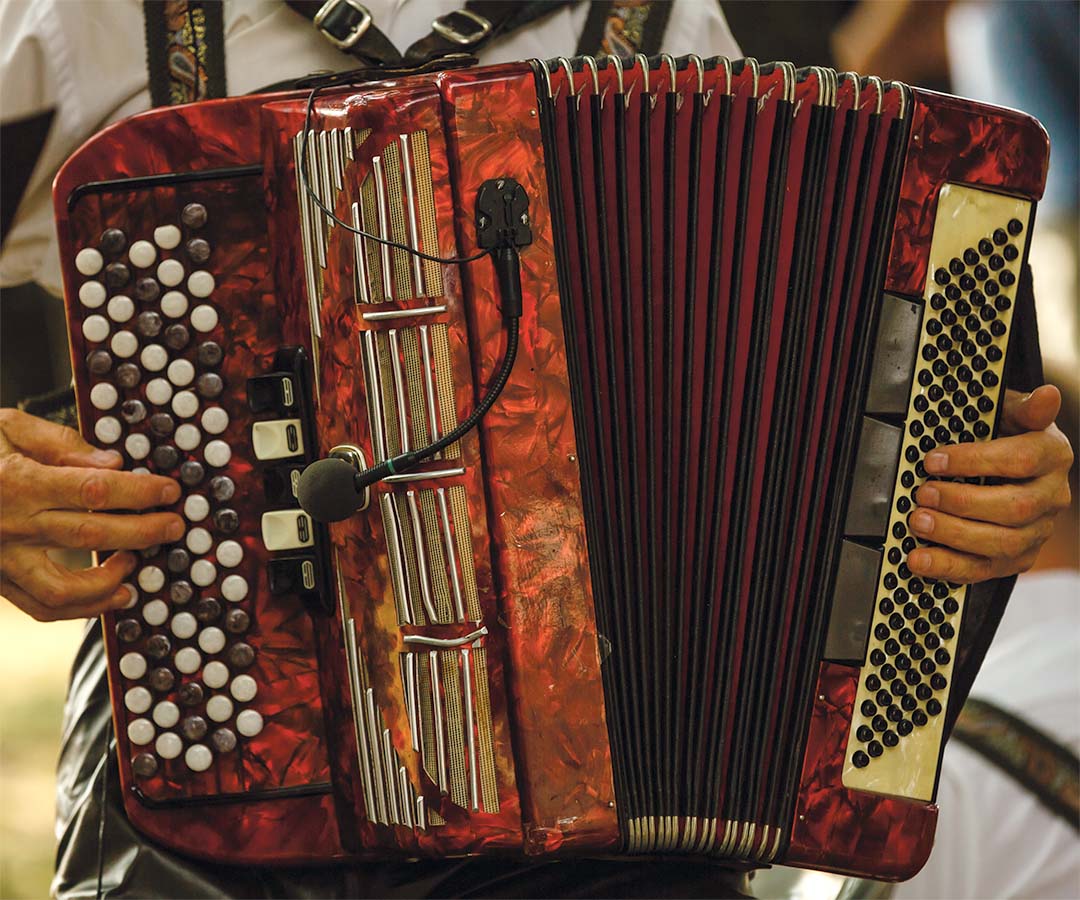 Acordeón rojo, instrumento emblemático de la música vallenata, tocado por un músico.