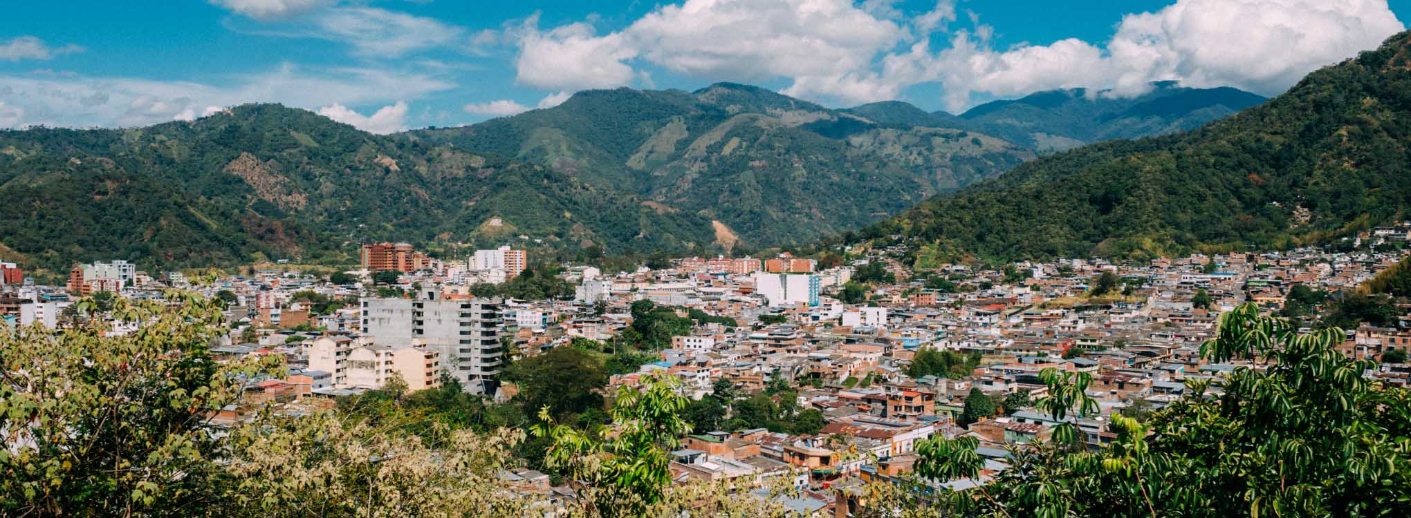 Vista panorámica de Ibagué, mostrando la ciudad rodeada de montañas y vegetación