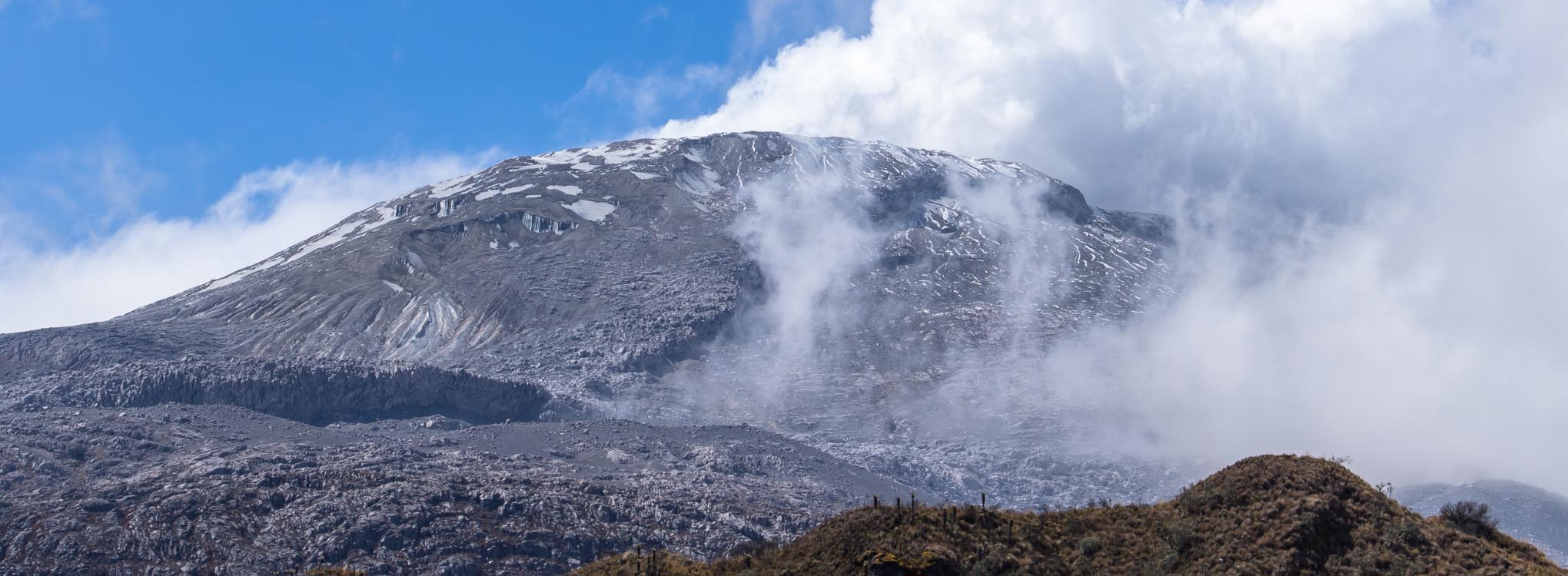 Vista panorámica del Nevado del Tolima con nubes rodeando su cumbre.