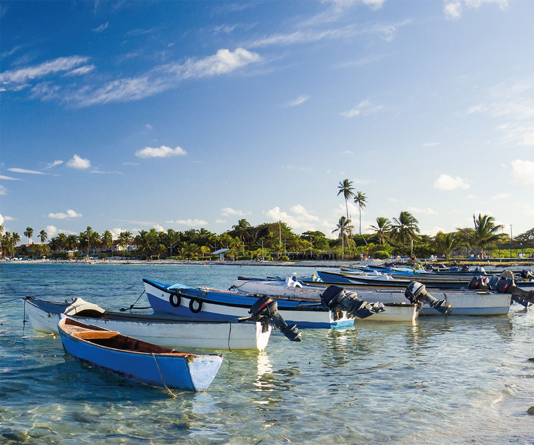 Botes tradicionales flotando en aguas cristalinas cerca de la costa de San Andrés.