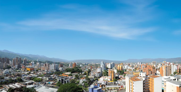 Panorámica urbana con edificios y montañas.