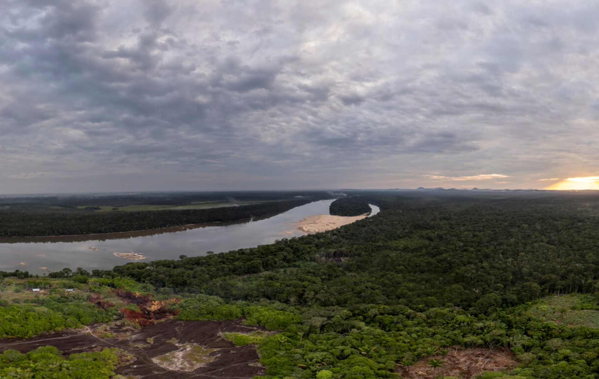 Vista panorámica desde el Cerro de Urania en Mitú, Colombia, mostrando un río serpenteante rodeado de selva tropical.