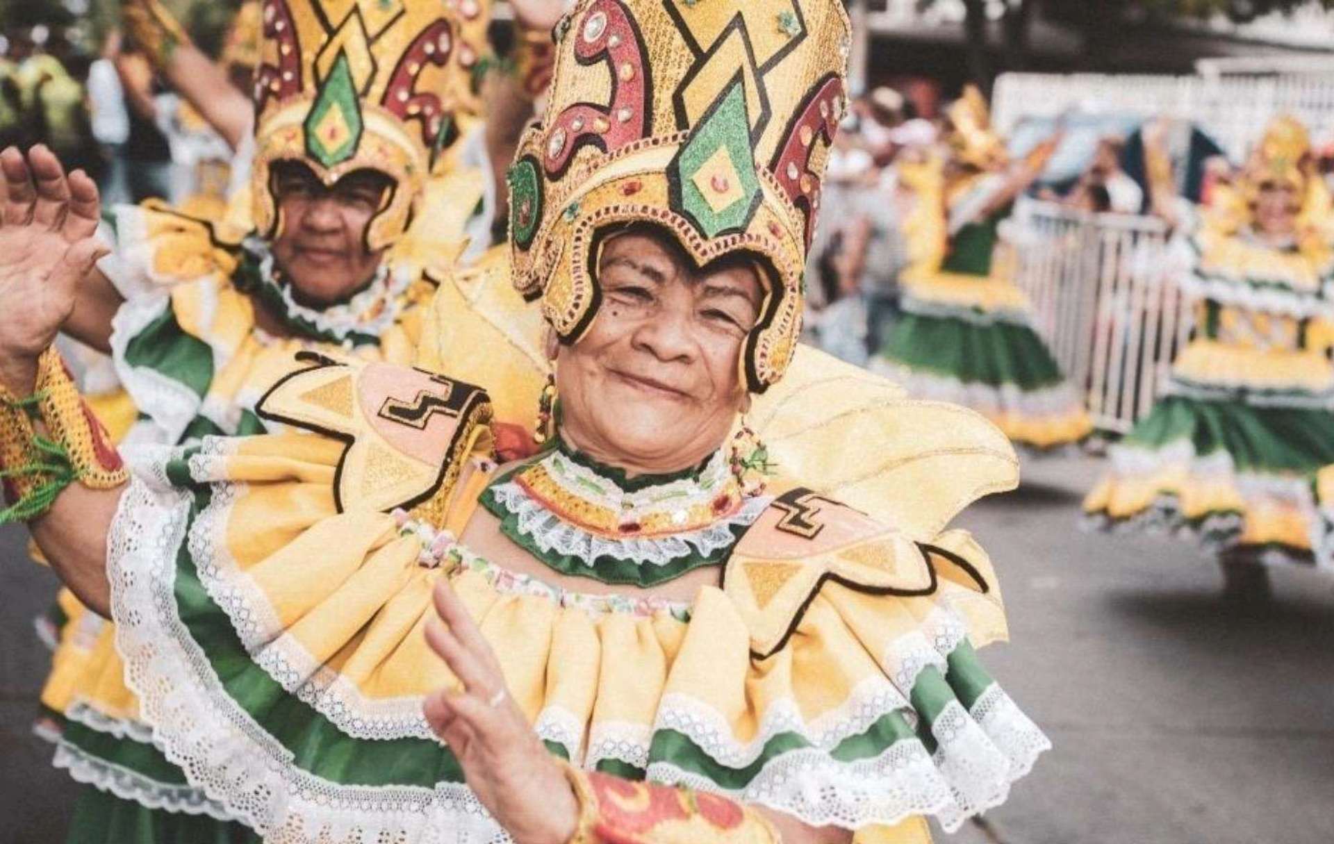 Mujeres mayores vestidas con trajes folclóricos coloridos, adornados con detalles en amarillo y verde 