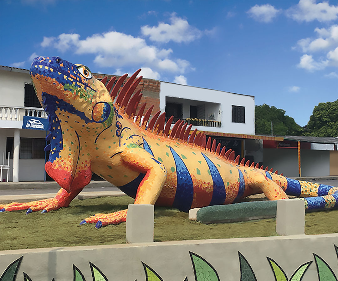 Escultura gigante de una iguana colorida en Sincelejo, destacando detalles vibrantes y un diseño artístico.