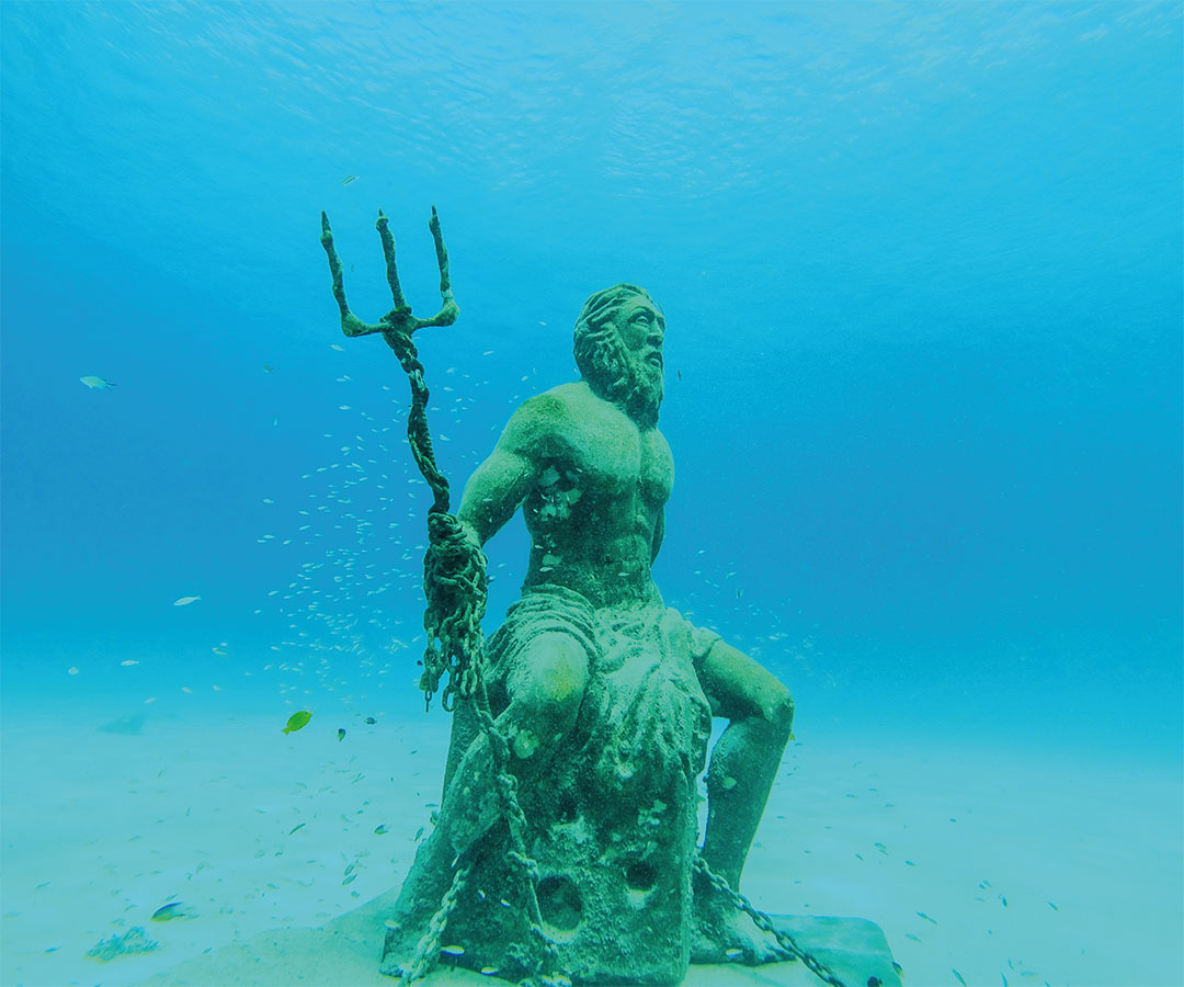 Escultura submarina de Neptuno, dios del mar, con un tridente en la mano.