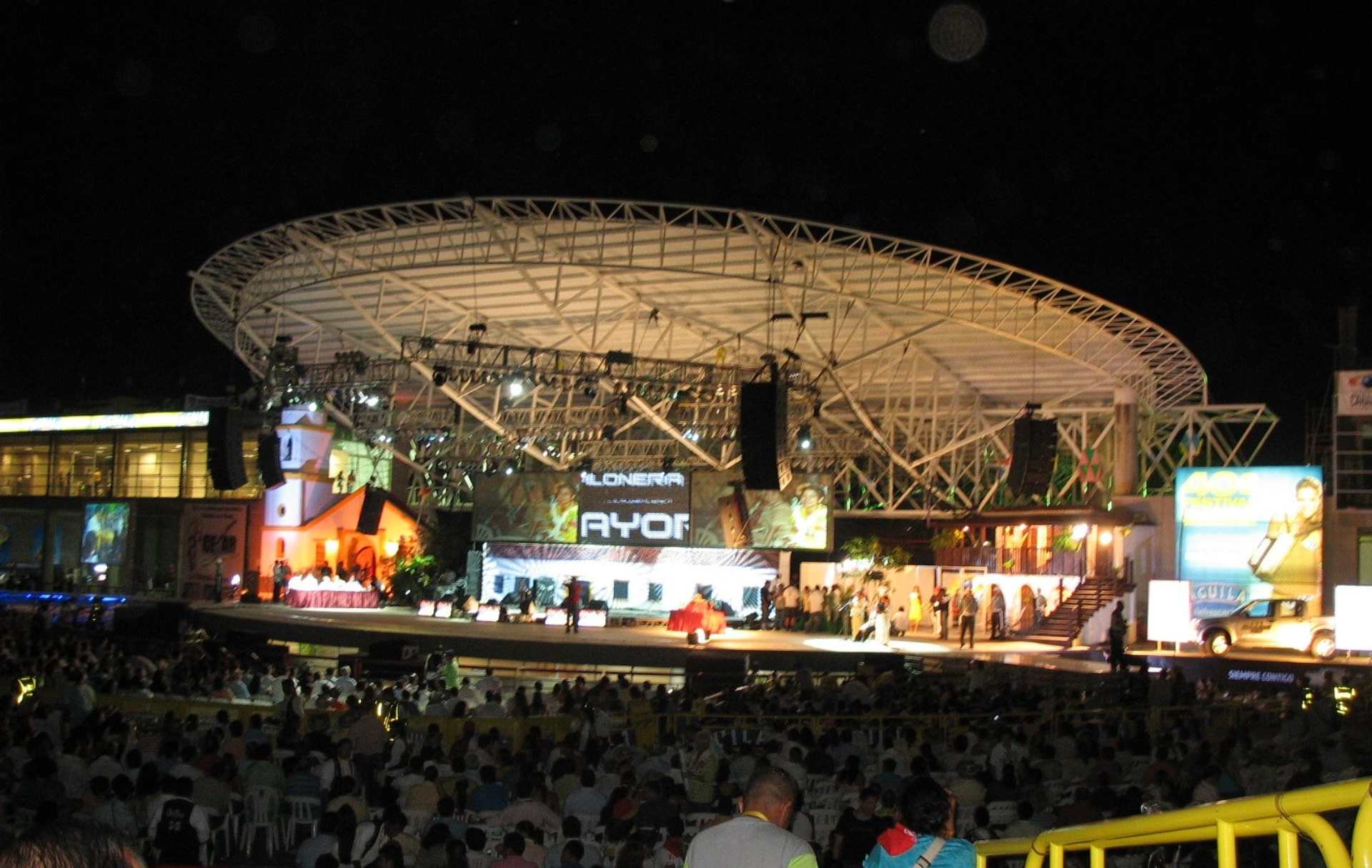 Escenario iluminado durante la noche en el Festival Vallenato, con un público numeroso