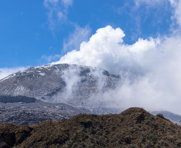 Vista panorámica del Nevado del Tolima con nubes rodeando su cumbre.