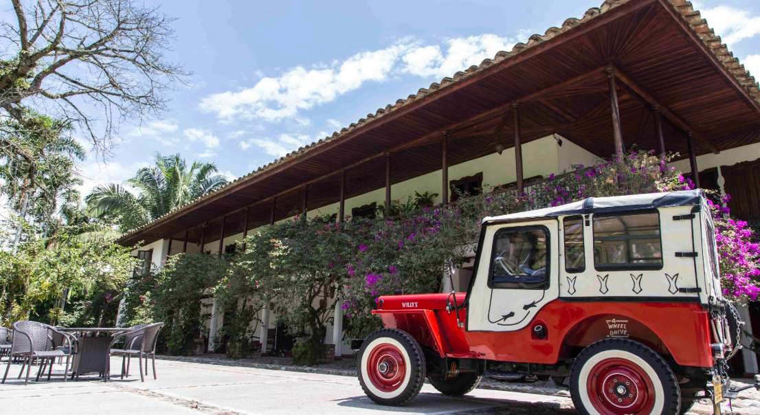 Hacienda colonial con jeep clásico.