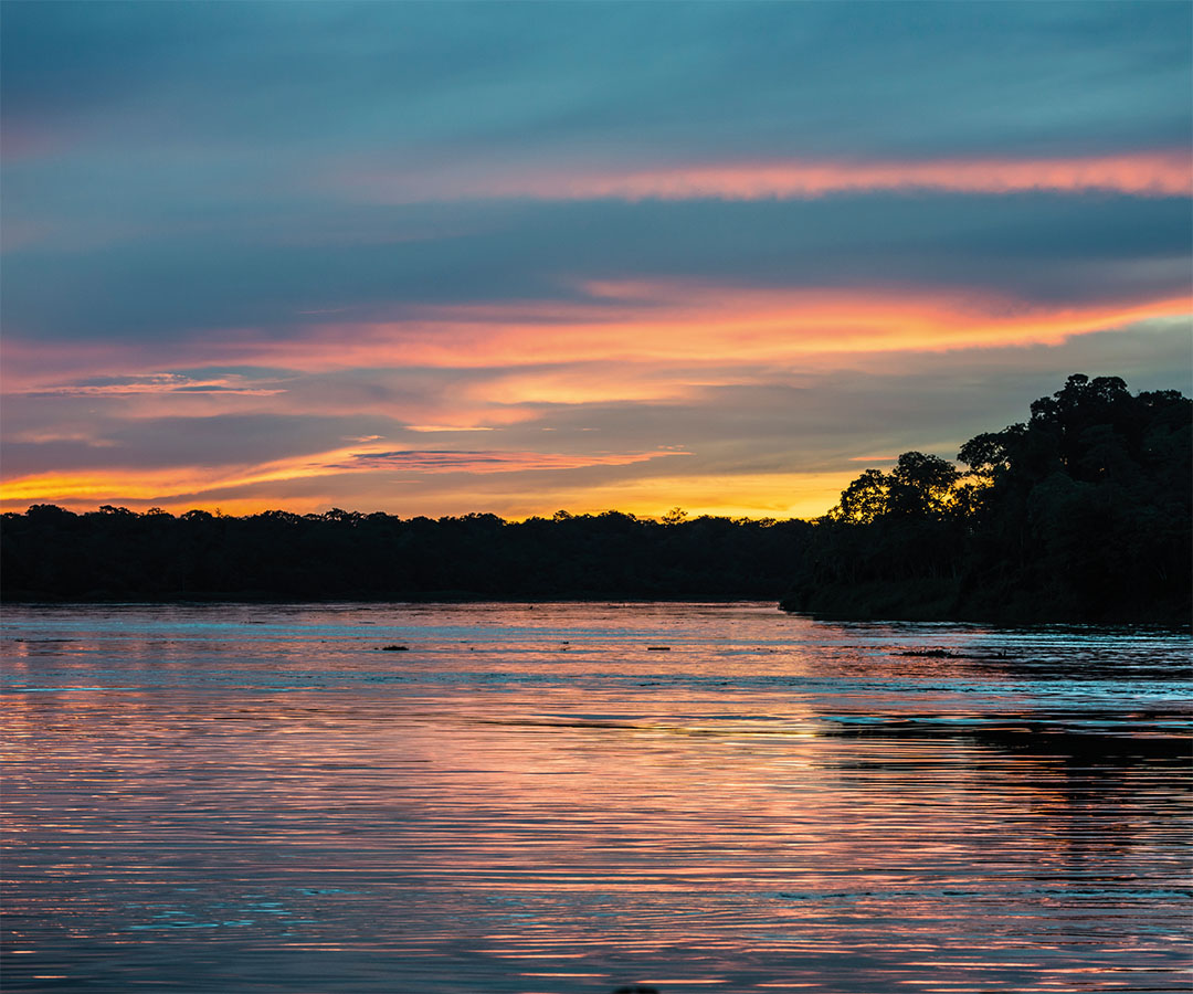 Paisaje fluvial al atardecer con tonos cálidos.