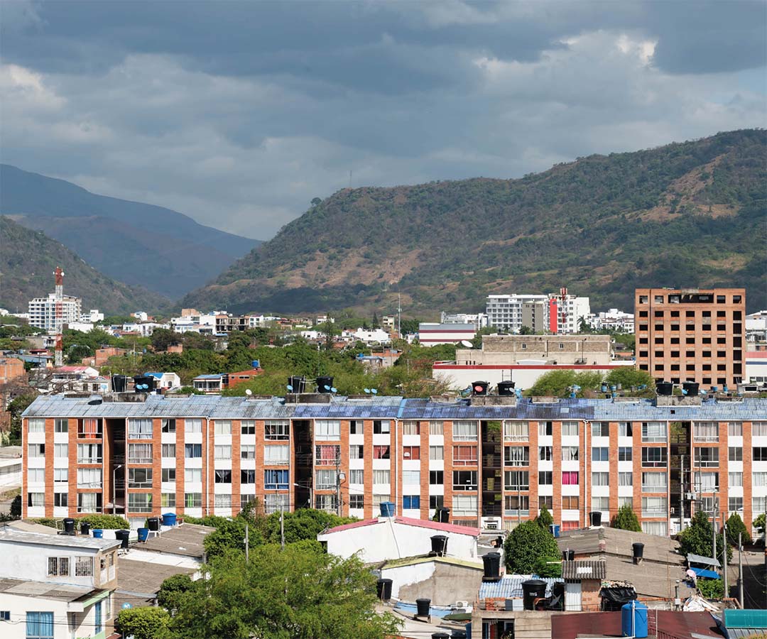 Panorama urbano con edificios de apartamentos y montañas en el fondo.