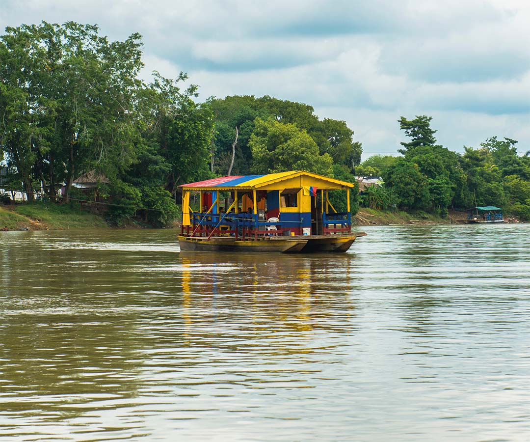 Planchón tradicional navegando por el río Sinú en Montería.