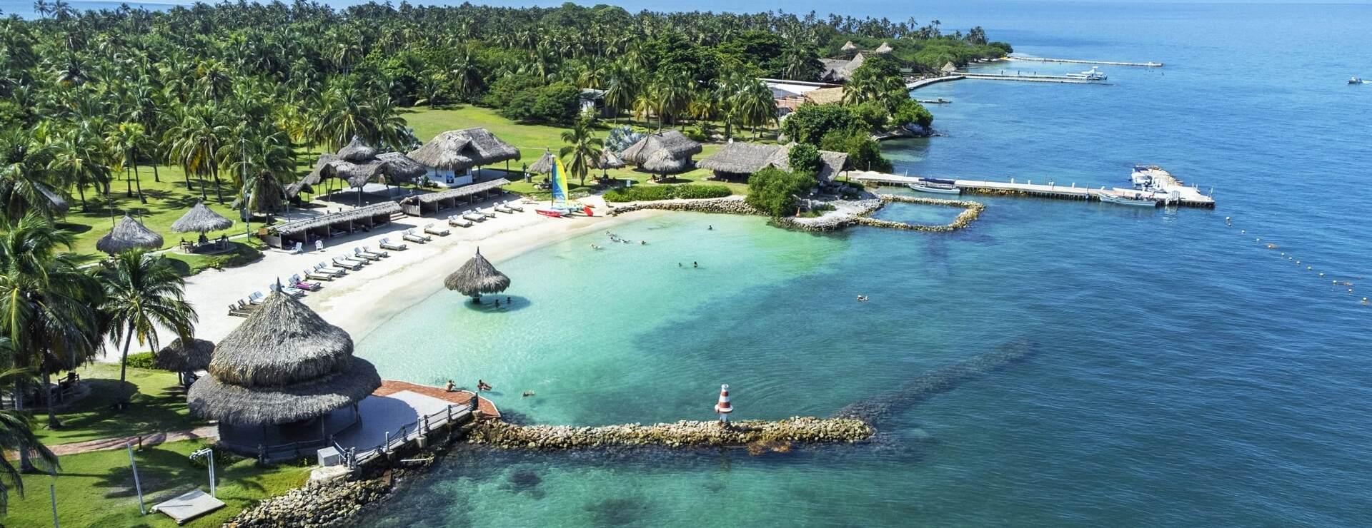 Isla tropical con playas de arena blanca y palmeras.