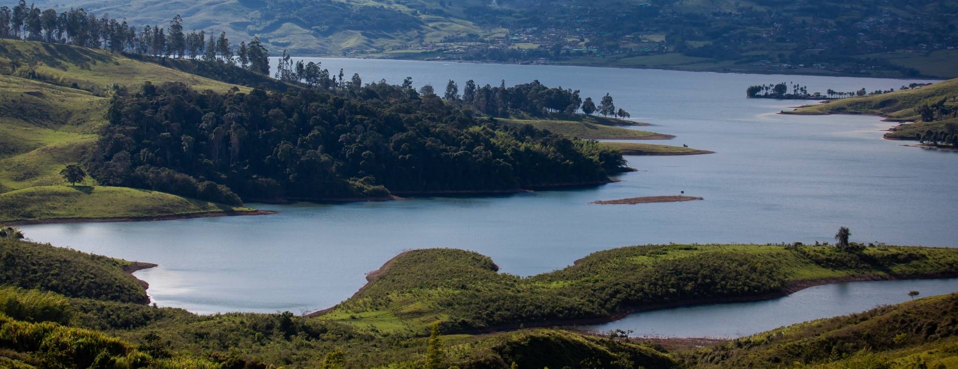 Lago rodeado de colinas verdes.