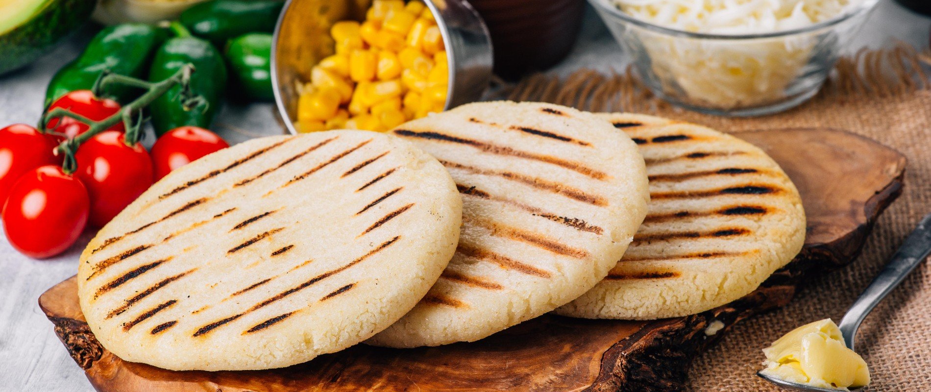 Arepa lista para rellenar en medio de comida.