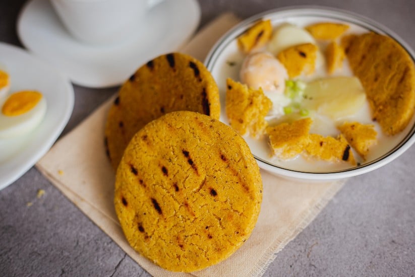 Arepa santandereana al lado de una changua. 