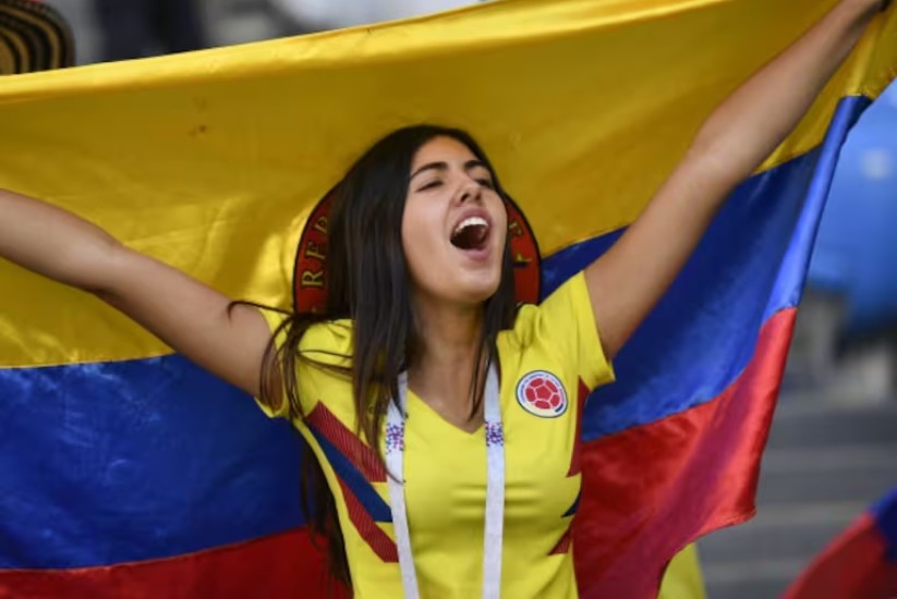 Mujer cantando con bandera de Colombia