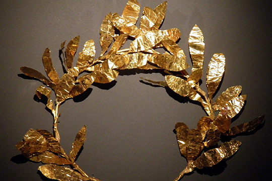 Fotografía de una diadema de oro con fondo color café, oro de Colombia, metal precioso, Materias Primas Colombianas
