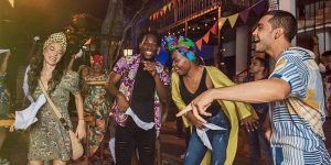 Fotografia de cuatro amigos en una fiesta sonriendo y bailando, cerveza artesanal, cerveza artesanal colombia