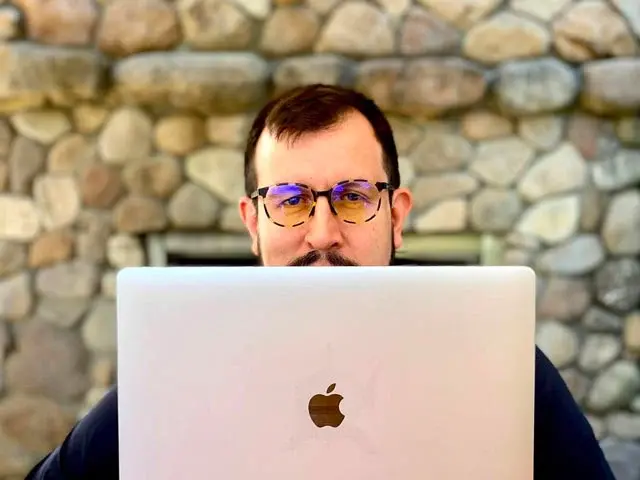 Alexander Torrenegra con gafas frente a su computador portátil