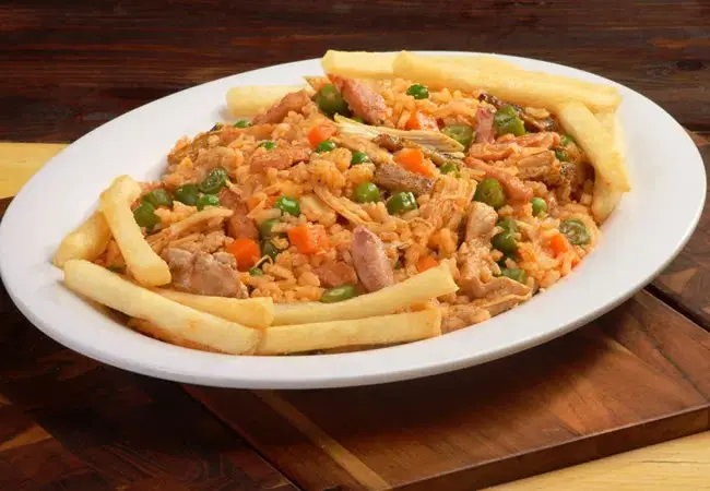 Chicken and rice dish with french fries.