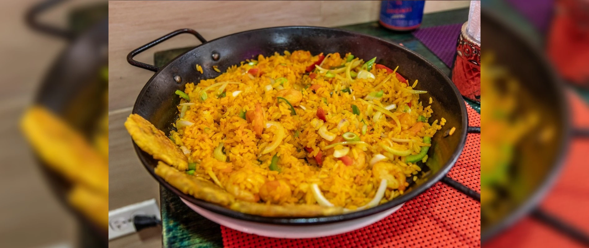 Arroz típico de la Costa Caribe de Colombia, servido en un sartén con vegetales y plátano frito