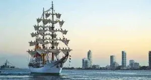 Buque ARC Gloria navegando cerca de la costa de Cartagena con fondo urbano.