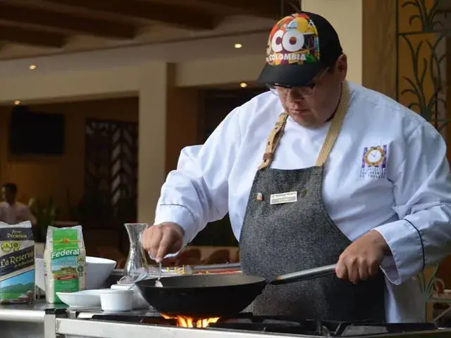 Chef cocinando en un wok sobre una estufa con fuego, con ingredientes