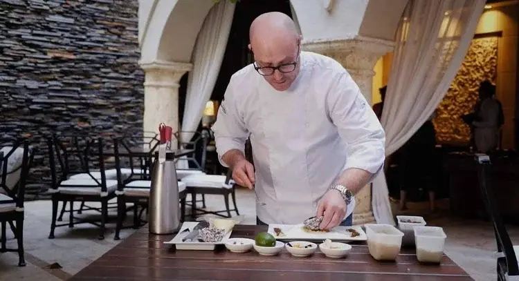 Chef colombiano Rausch preparando un plato gourmet en un restaurante