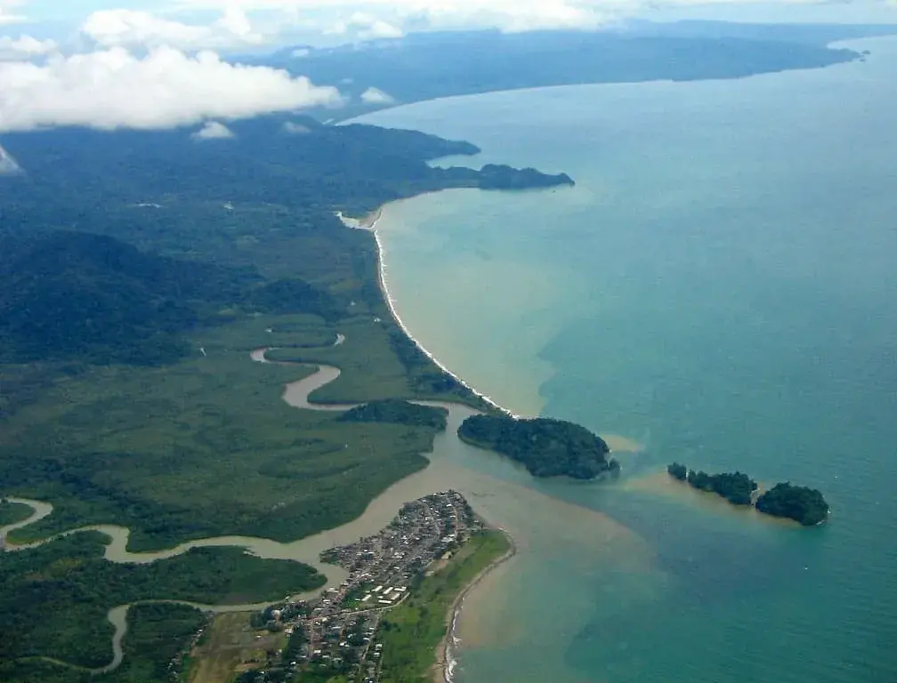 Vista aérea de la costa del Pacífico en Chocó con río y poblado.
