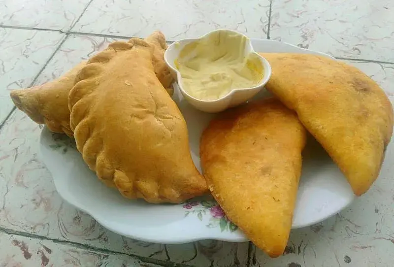 Empanadas antioqueñas con salsa en plato blanco