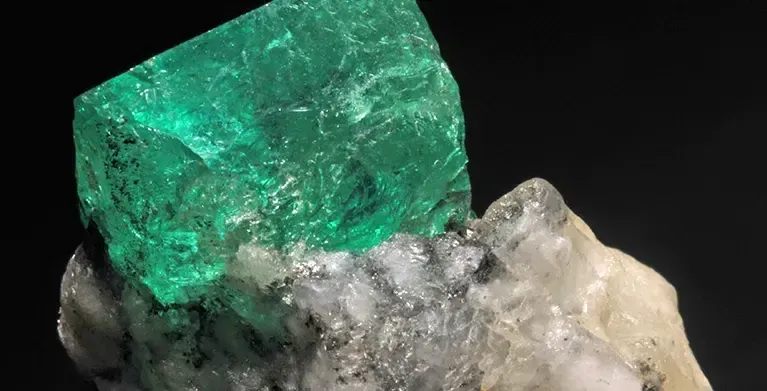 Esmeralda incrustada en una roca clara