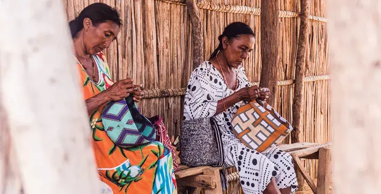 Mujeres wayuu tejiendo mochilas en La Guajira. ¡Mira qué artesanía tan hermosa!