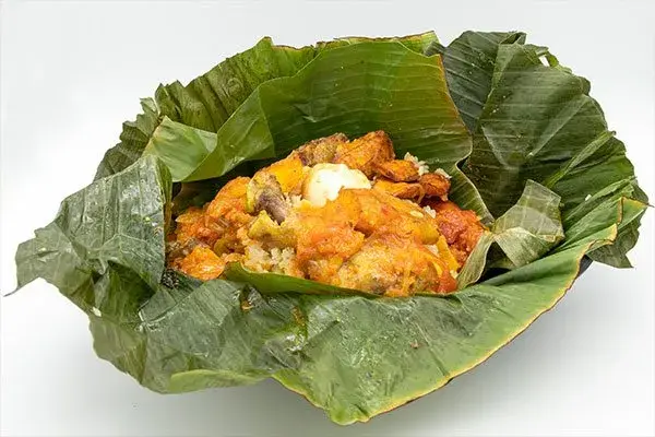 Fiambre paisa servido en hoja de plátano con carne y arroz.