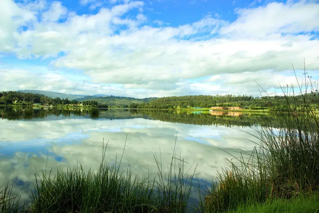 Cielo azul y nubes reflejadas en el tranquilo Lago Sochagota, Paipa.