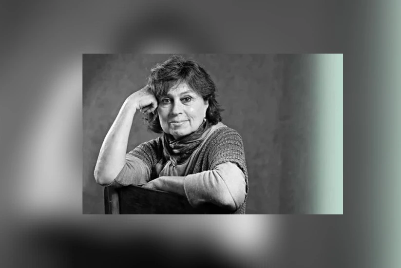 Retrato de Laura Restrepo apoyando el brazo y la cabeza sobre el respaldo de una silla