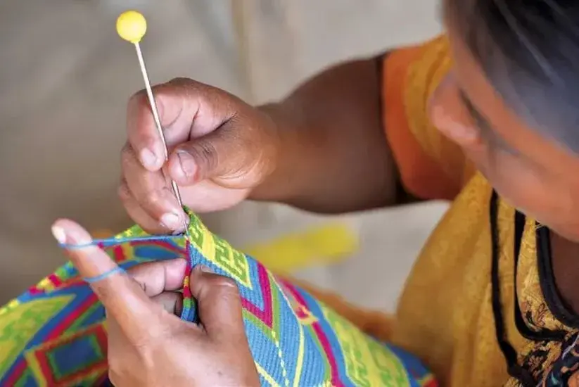Wayúu woman weaving a design