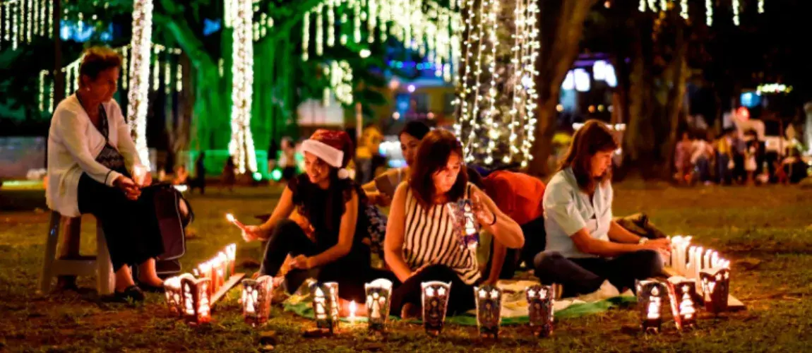 Mujeres en picnic nocturno encendiendo velas y faroles navideños noche