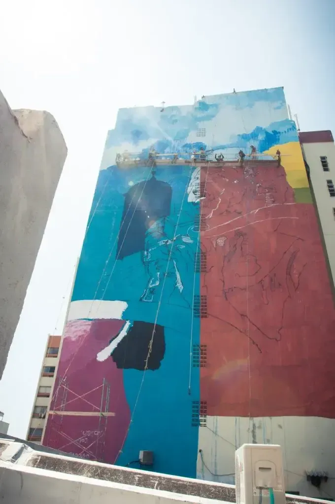 Etapa inicial del mural en fachada de edificio urbano