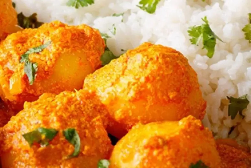 Papas chorreadas servidas con arroz blanco y cilantro fresco