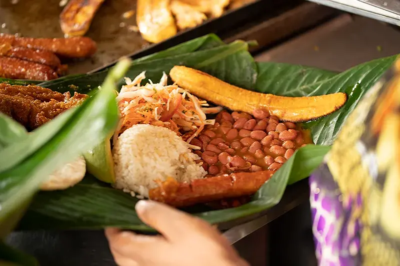 Plato colombiano con arroz, frijoles, plátano maduro y carne.