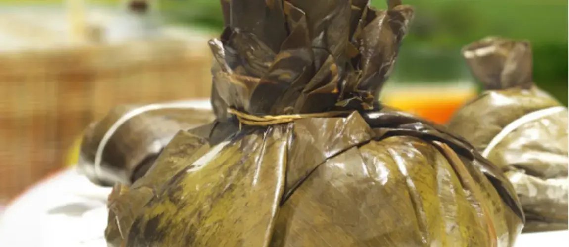 Tamal envuelto en hojas de plátano y atado con hilo