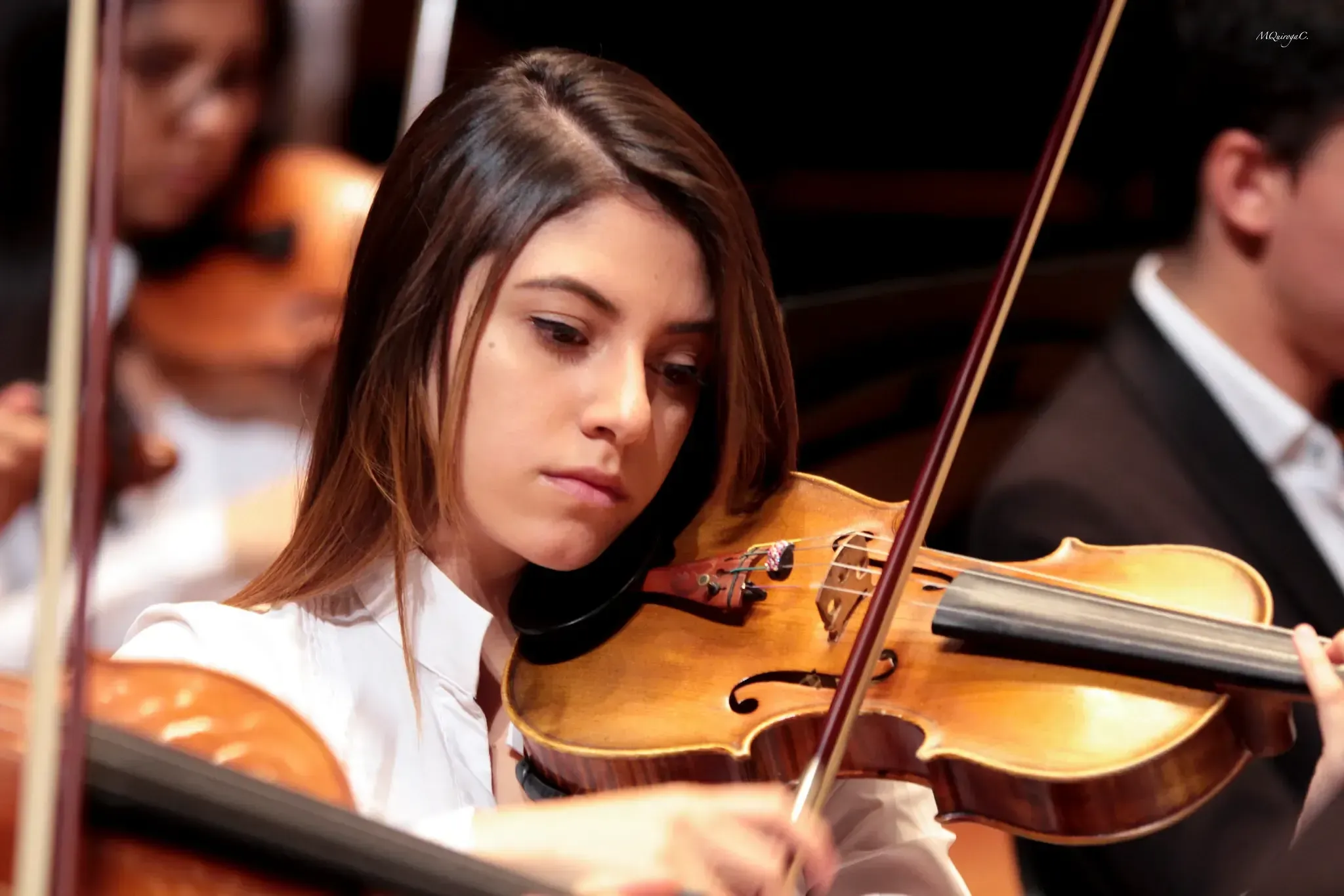 Violinista joven concentrada tocando durante el concierto